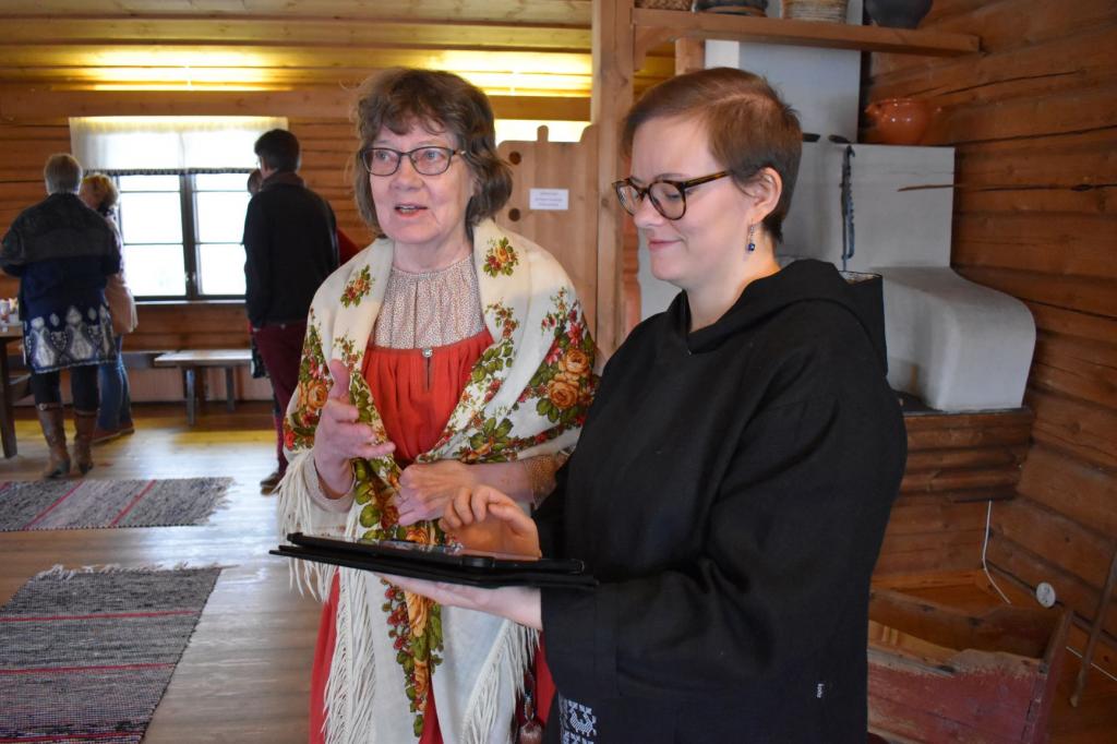 Project worker Sini-Maria Melanen (right) showed how to use the Parppeinvaara Rune Singer's Village mobile guide on a tablet to event participant Raija Klemola